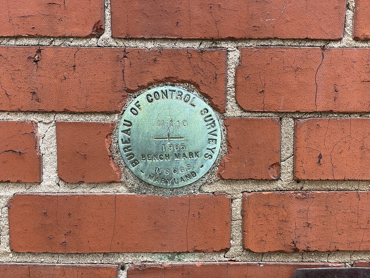A US Coast and Geodetic Survey BENCH MARK disc set into red brick