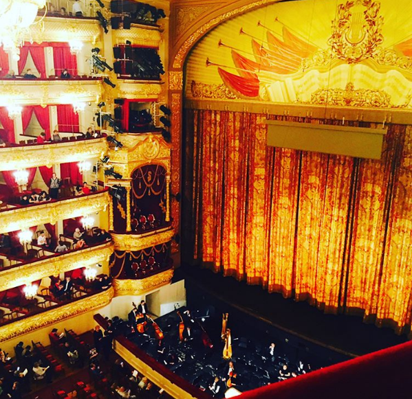 The closed front curtain of the Bolshoi Theatre, deep red with gold detailing